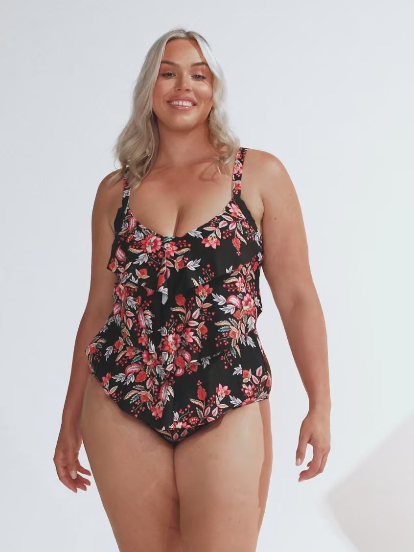 model wearing black and red floral ruffle swimsuit