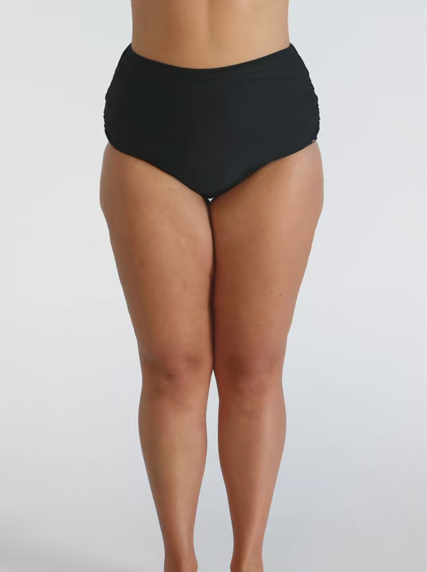 Model in  studio wearing a high waisted belly pant with side ruching