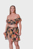 Model wearing women's beach wrap skirt in mesh fabric floral print with orange, red and yellow tones