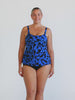 Blonde model in studio wearing a blue and black tank tankini top in chlorine resistant