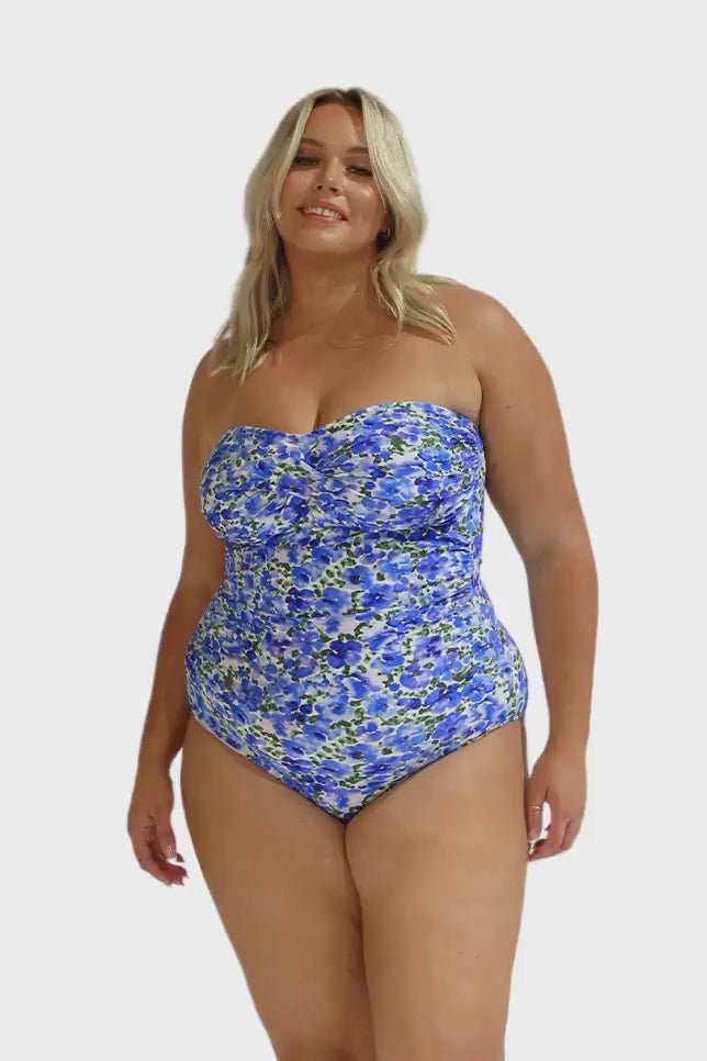 Model wearing blue floral strapless one piece swimsuit