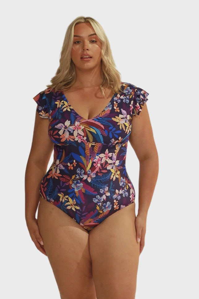 model wearing navy floral v neck frill sleeve one piece