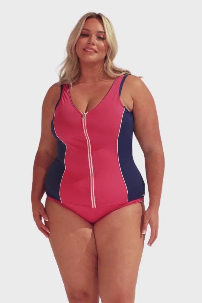 Model wearing navy and pink zip up tankini with matching pink bottoms