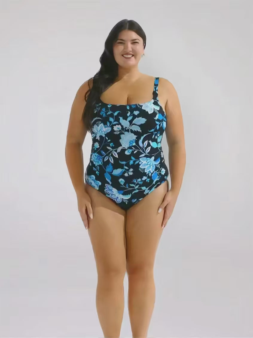 Brunette model in studio wearing a floral blue tank one piece