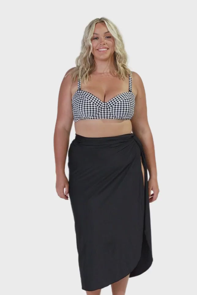 model wearing long black split skirt over retro bikini