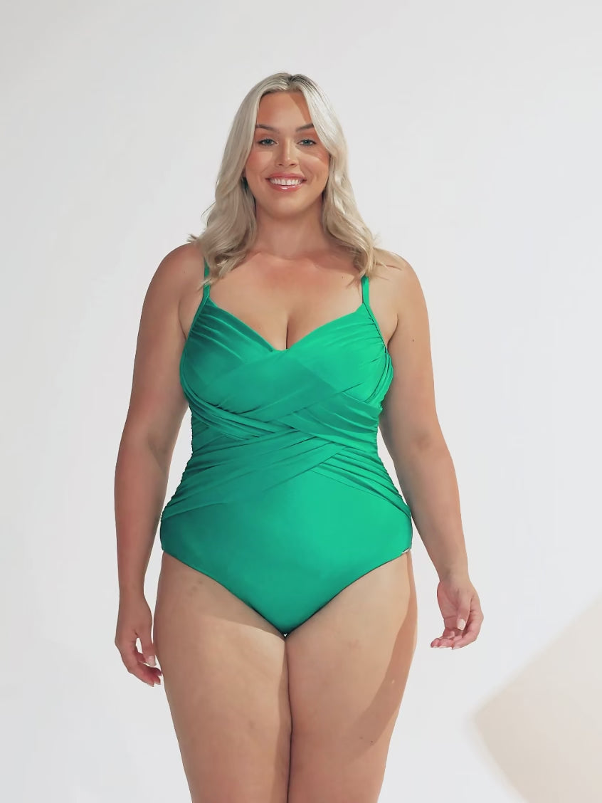 model wearing metallic green criss cross one piece