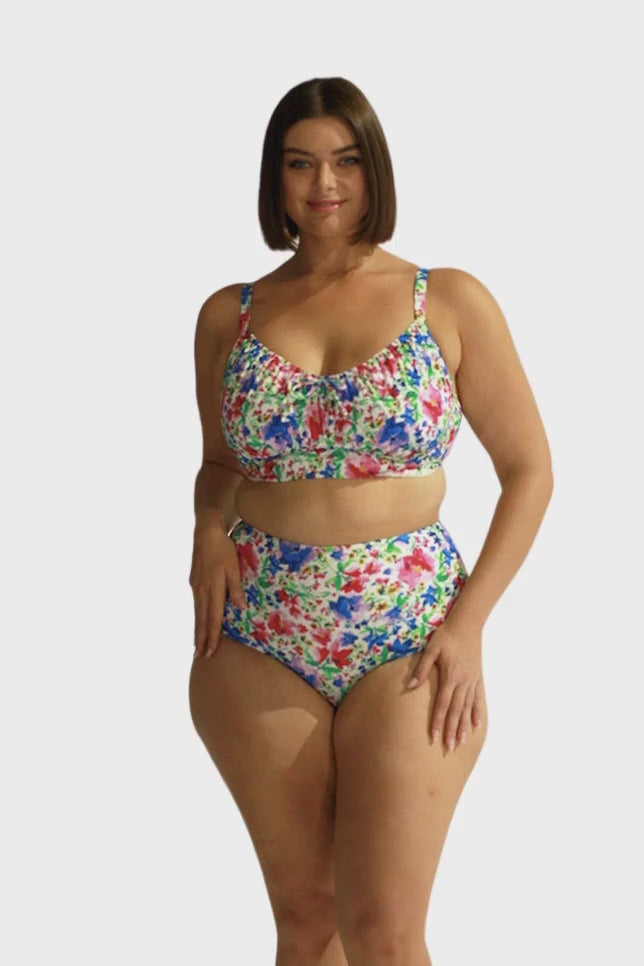 brunette model wears bright floral underwire bikini top with adjustable straps