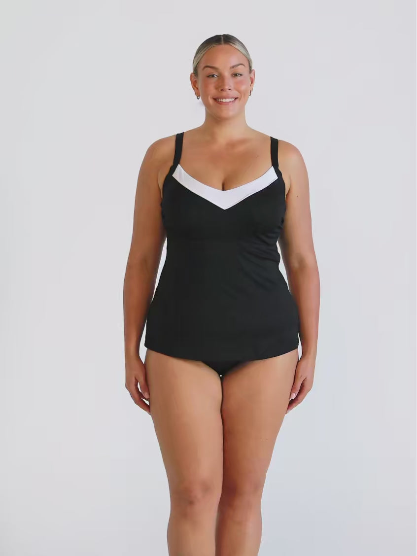 Blonde woman wearing a underwire tankini top with white trim and textured fabric