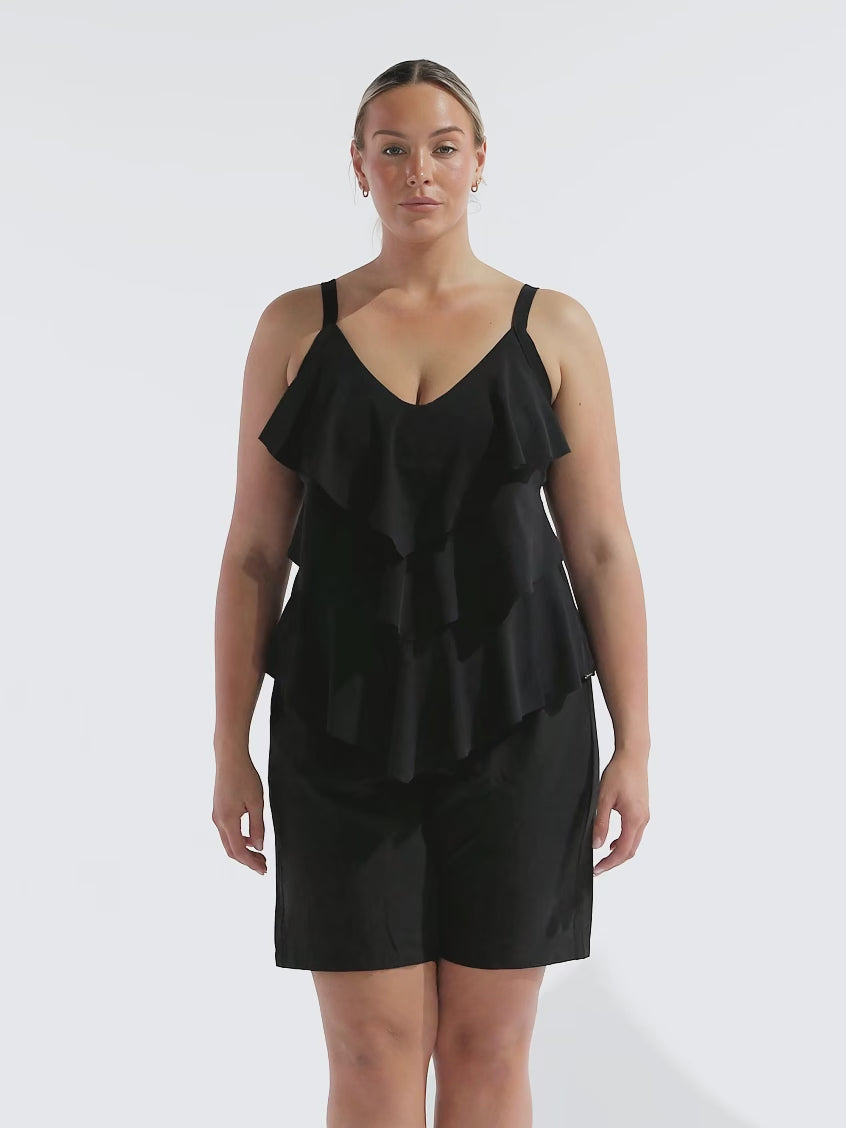 model wearing black board shorts with frilly tankini