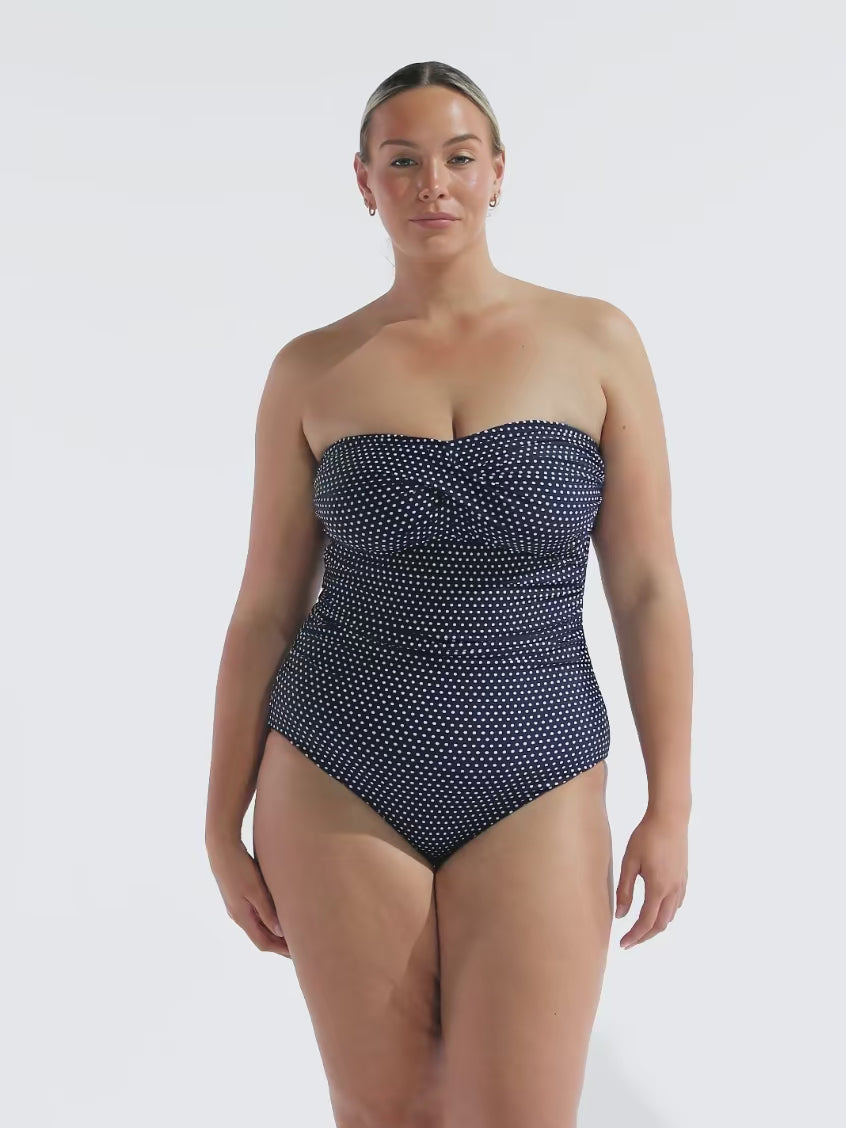 model wearing navy and white dots strapless one piece