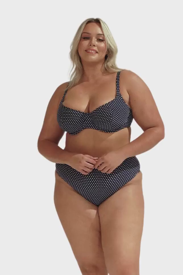 model wearing navy and white dots bikini top and high rise pant