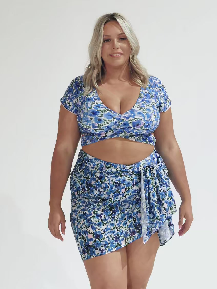 model wearing blue floral wrap sarong and matching bikini