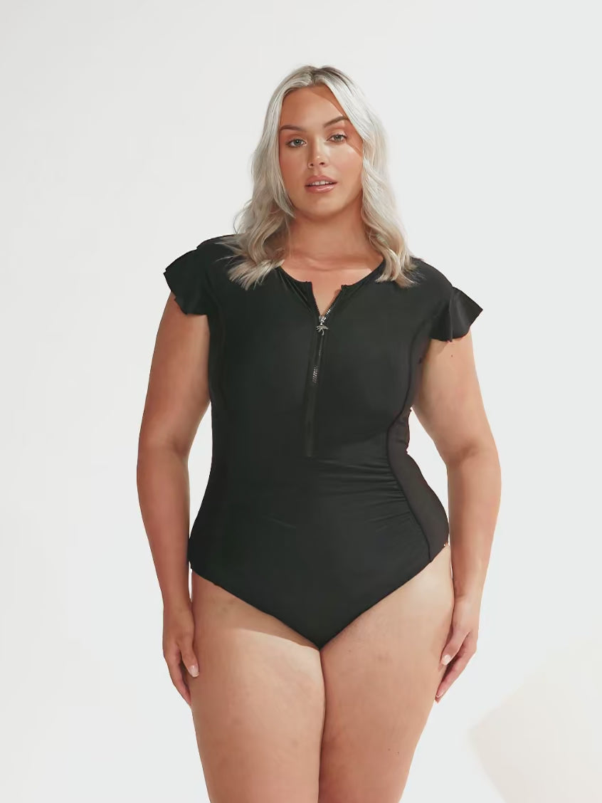 blonde model wearing black zip front swimsuit with frill sleeves