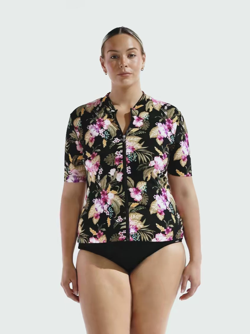 Model in studio showing off short sleeve rash vest in floral print 