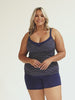 Model wearing navy boyleg shorts with navy dots tankini