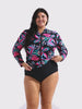 Woman in studio wearing a long sleeve rash vest with zip front detail in pink and green floral print