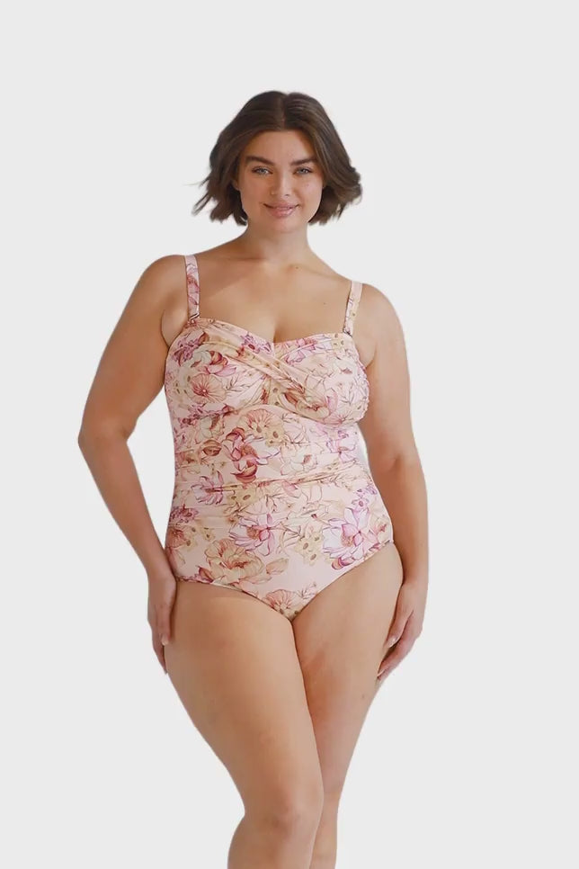 Brunette plus size model wears peach floral bandeau one piece for large busts