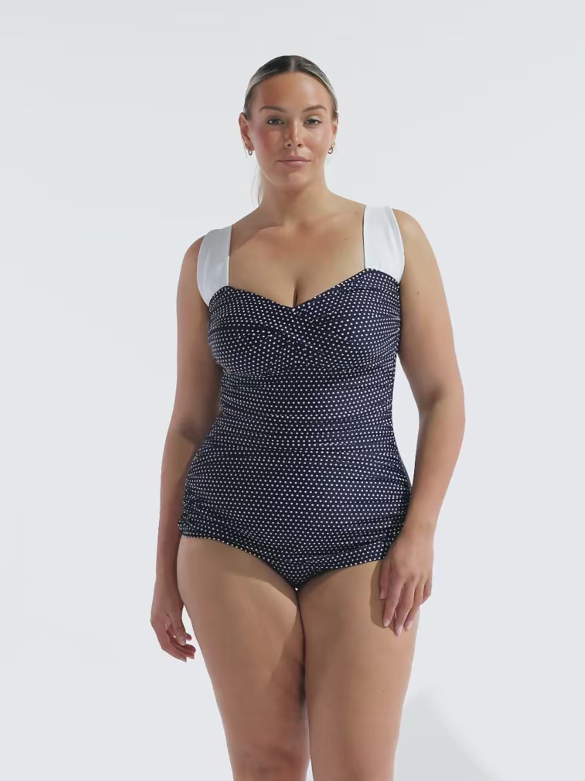 model wearing navy and white dots retro inspired women's swimsuit