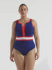 model wearing navy, red and white sporty zip front one piece