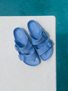 Blue sandals on a diving board over pool