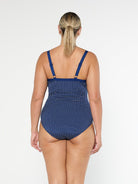 model showing back of navy polka dot one piece