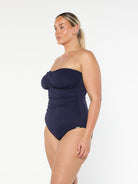 model showing side of navy strapless swimsuit