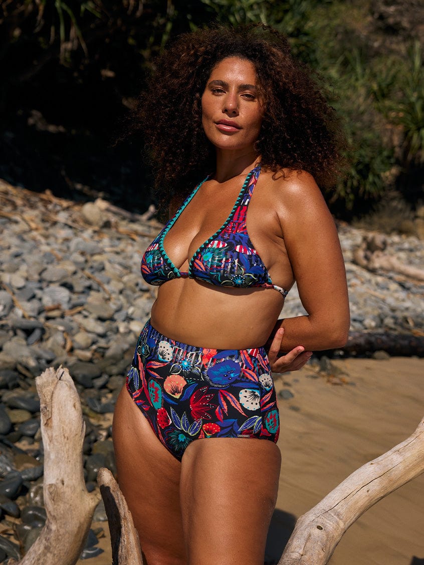 model wearing bright coloured floral bikini on beach