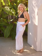 model wearing white cotton pants and black bikini top