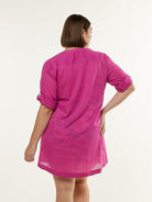 Back of model wearing pink beach overshirt
