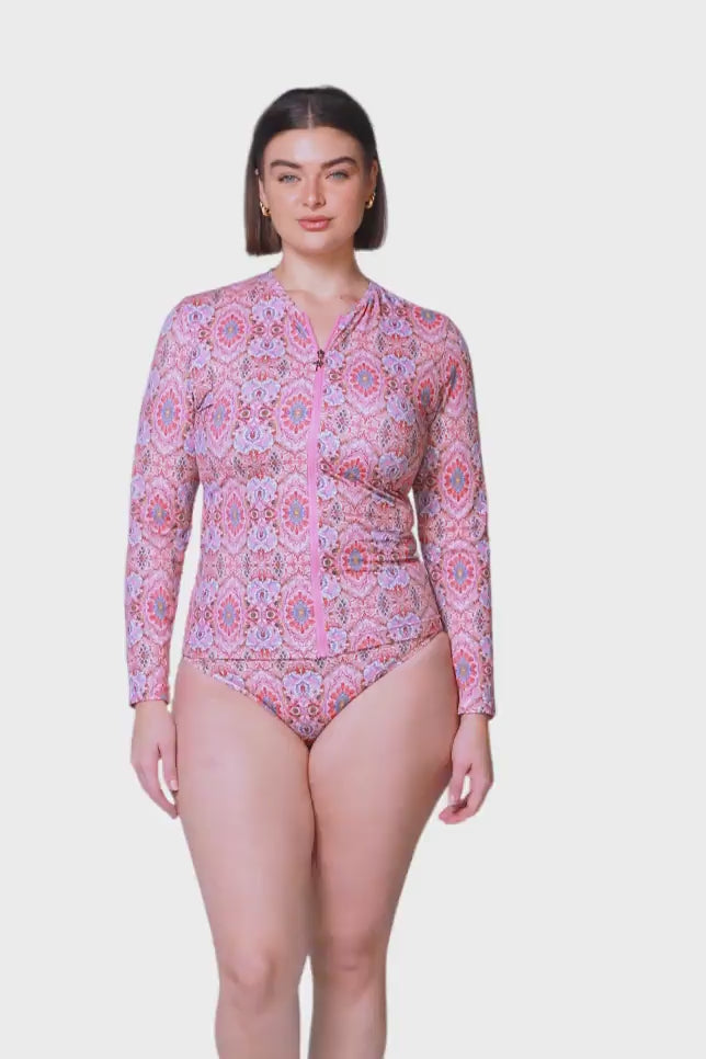 product video of brunette women wearing long sleeve pink mosaic rash vest with front zip