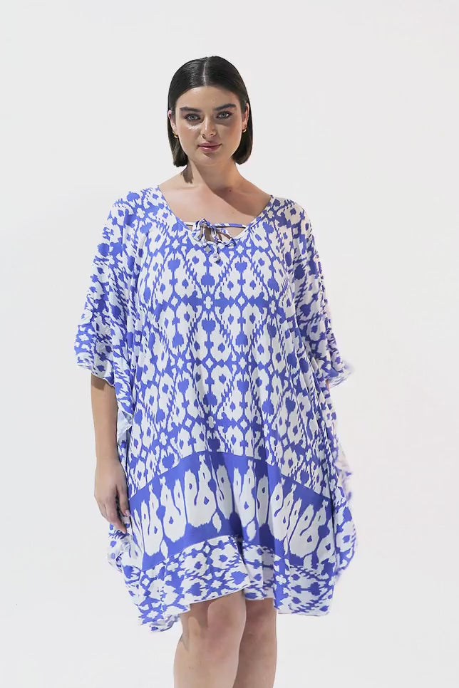 Brunette model wearing blue kaftan swim coverup