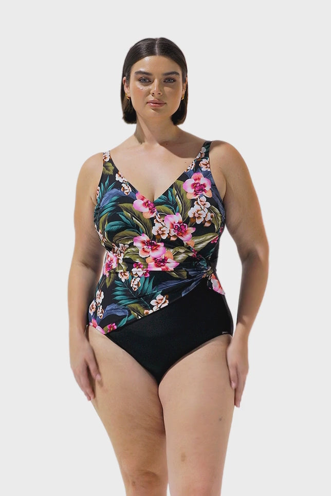 Video of brunette model wearing crossover floral one piece 