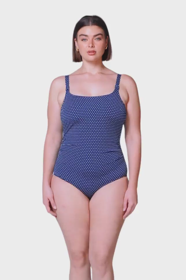 brunette model wears chlorine resistant navy tankini with low scoop back