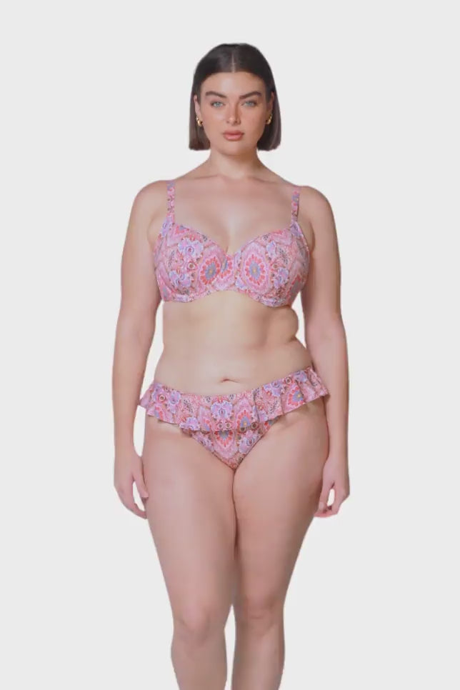 brunette women wearing pink supportive underwire bikini top with frill mid rise bikini bottoms 