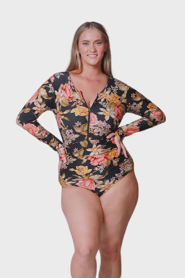 women wearing plus size one piece with long sleeves and front zip in pink and gold floral print