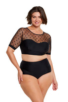 Brunette model wears black polkadot bikini top with mesh short sleeves