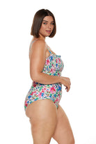Brunette model wears pink and blue floral shirred bandeau one piece swimsuit with removable straps