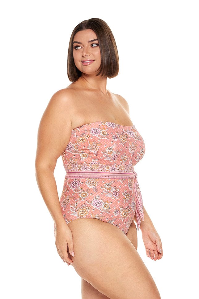 Brunette model wearing pink floral strapless bandeau one piece with underwire support and removable belt