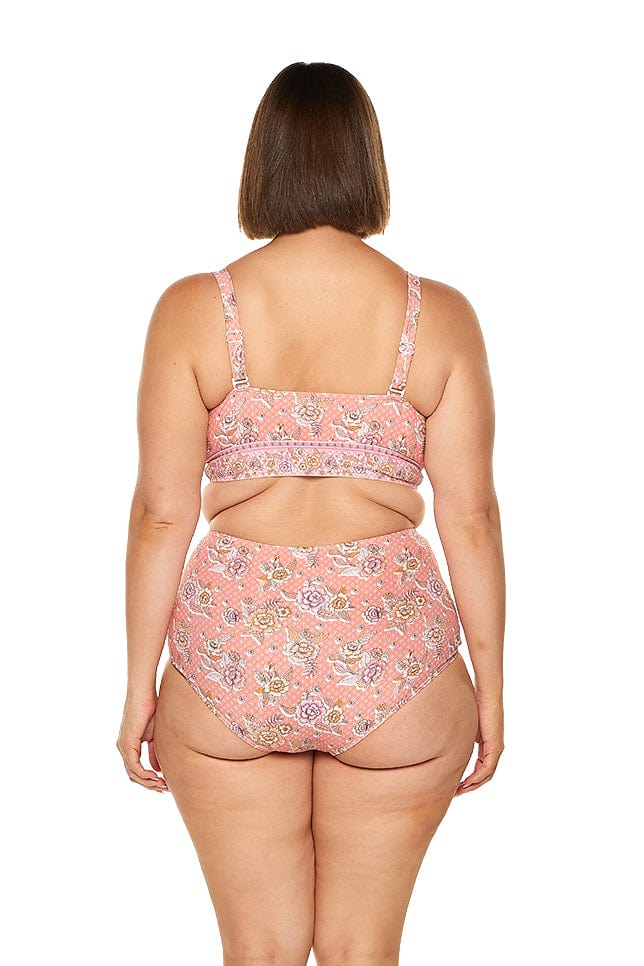 brunette model wears supportive pink floral bikini top with adjustable back straps