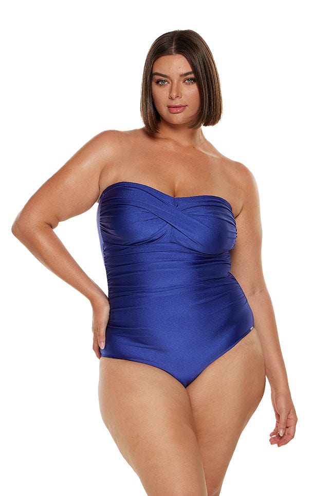Brunette women wears sapphire blue bandeau one piece with removable straps