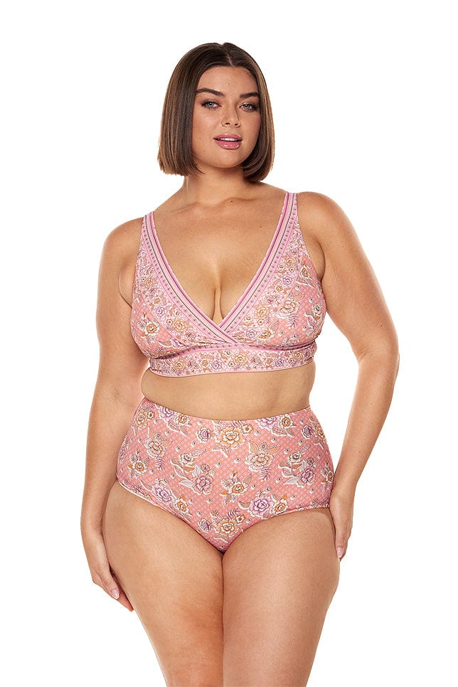 Brunette model wears supportive low neck bikini top in floral pink print