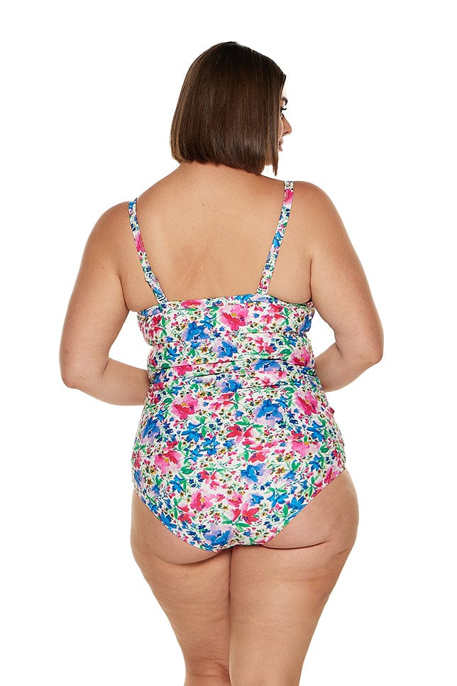 brunette model wears pink and blue floral ruched underwire tankini top and high waisted pant