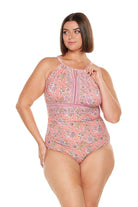 Brunette women wears apricot pink floral one piece with high keyhole neckline and stomach ruching