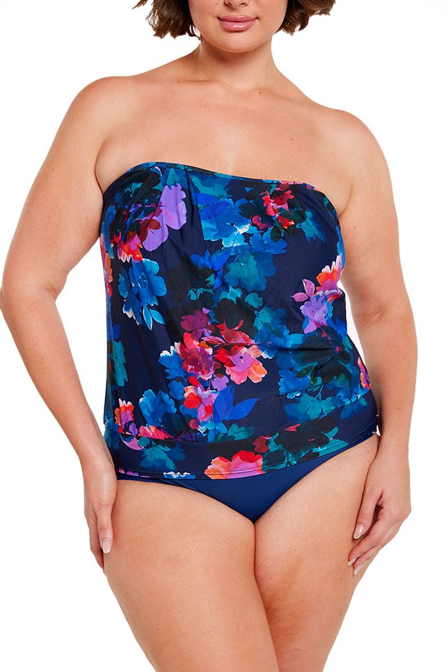 Brunette model wears strapless flouncy bandeau tankini top in navy blue floral print