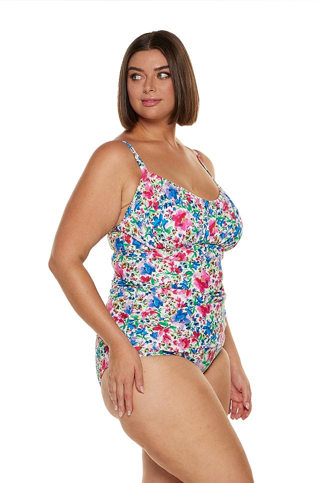 brunette women wears pink and blue floral tankini top with underwire support and adjustable straps 