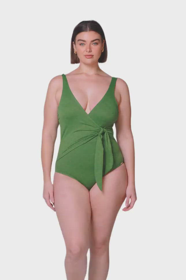 product video of brunette model wearing acapulco green textured one piece with v neck and wrap design