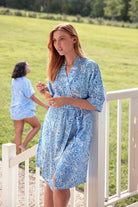 Model wearing blue paisley robe standing on deck 