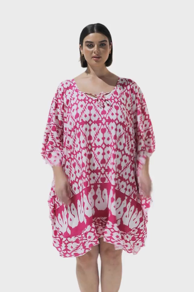 Brunette model wearing pink patterned kaftan cover up dress