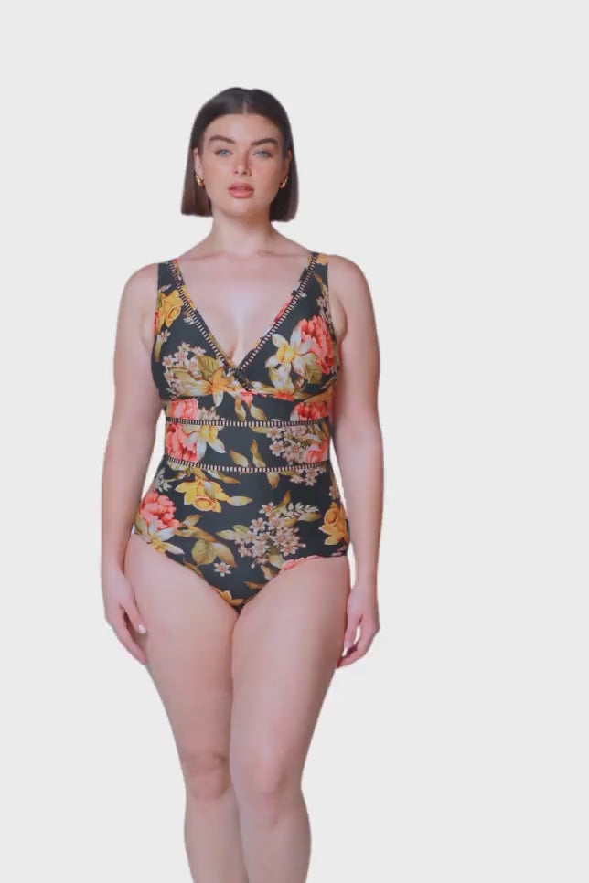 brunette size 14 women wearing black based floral one piece with V neckline