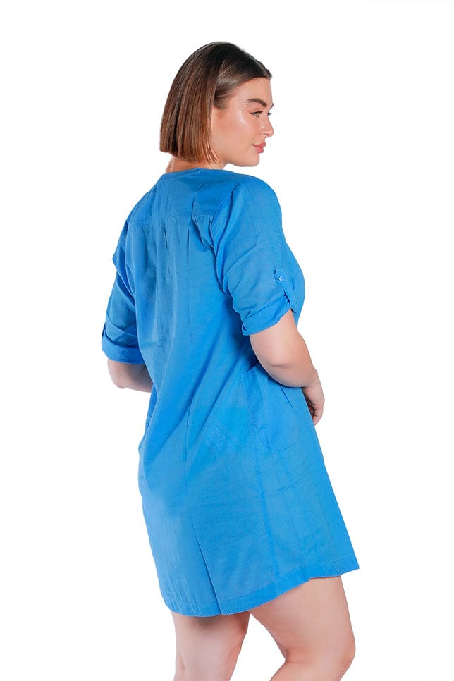 model wears blue cotton shirt over swimwear with adjustable sleeves